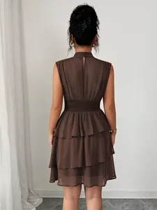Dettaglio del vestito a balze marrone senza maniche con collo alto visto da dietro.
