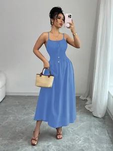 Blue sleeveless spaghetti strap maxi dress with shirred waist in an indoor setting