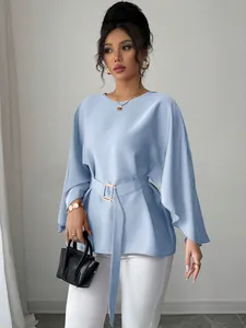 Full view of elegant light blue bell sleeve blouse featuring a matching buckled belt