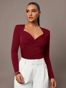 Vista dettagliata di un elegante body in velluto bordeaux con scollo a V e design incrociato