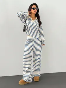 Dettaglio del completo in maglia a righe blu con maglia a maniche lunghe e pantaloni larghi.