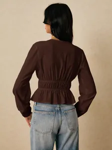 Back view of brown V-neck blouse with elasticated waist and ruffled peplum hem.