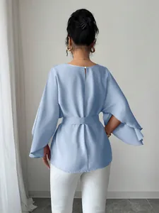 Back view of elegant light blue bell-sleeve blouse with waist belt and pearl detail