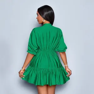 Elegant emerald green puff sleeve mini dress with pleated waist and ruffled hem details.