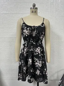 Vue détaillée d'une robe d'été noire à imprimé floral avec bretelles spaghetti et petit nœud.