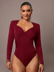 Dettaglio di body in velluto bordeaux con scollo a V incrociato e design arricciato