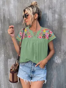 Bohemian green embroidered blouse featuring intricate tassels and stylish tie-neck design.