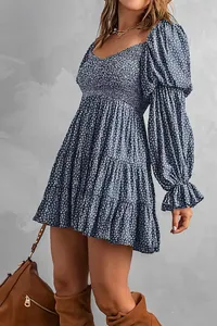 Detailansicht eines blau geblümten Minikleides mit gesmoktem Oberteil und gestuftem Rock.