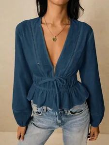 Close-up of deep V-neck dark blue blouse with delicate lace trim and ruffle hem details
