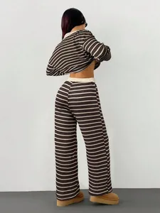 Vista posteriore di un completo trendy in maglia a righe marroni e beige con pantaloni