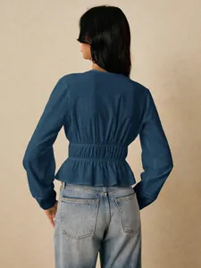 Back view of elegant dark blue long sleeve peplum shirt with cinched waist detail