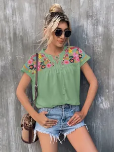 Casual boho green blouse featuring intricate floral embroidery and tassel drawstring neck