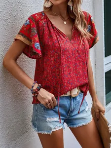 Détail d'une blouse bohème rouge à fleurs avec col en V, volants et lacets