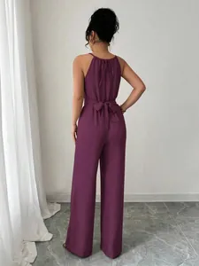 Κομψή μωβ ολόσωμη φόρμα halter με φιόγκο στη μέση και φαρδύ μπατζάκι για γυναίκες.