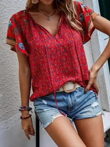 Gros plan d'une blouse rouge à fleurs ethniques avec col en V et short en jean
