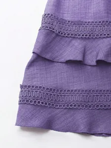 Visuale dettagliata del tessuto dell'abito viola con pizzo e balze stratificate.