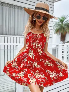 Détail du motif floral rouge et de la taille élastique sur une robe d'été légère.