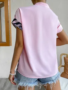 Détail arrière d'une chemise rose à manches courtes avec empiècements à fleurs