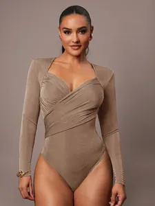 Dettaglio ravvicinato del body in velluto marrone con elegante scollo a V incrociato drappeggiato