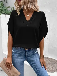 Close-up detail of black V-neck blouse featuring elegant lace trim and loose bell sleeves
