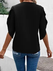 Detailed back view of a loose black summer blouse with elegant flutter sleeves