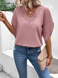 Detail view of a pink V-neck blouse featuring delicate floral lace trim and bell sleeves.
