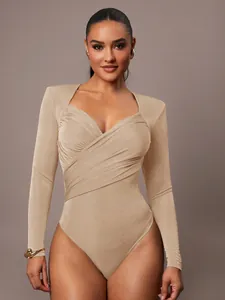 Dettaglio di un body in velluto beige con scollo a V incrociato e maniche lunghe moda