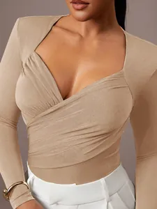 Primo piano di un body in velluto beige con scollo a V e design incrociato