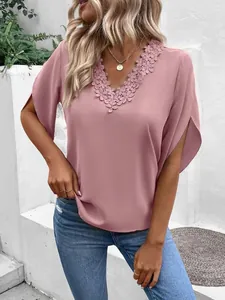 Detail view of a dusty pink V-neck blouse with intricate lace trim and split bell sleeves