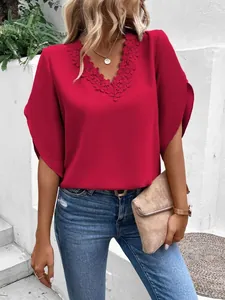Close-up of red V-neck blouse with intricate lace trim and flared bell sleeves