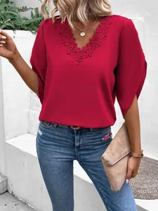Close-up of elegant V-neck blouse with intricate lace floral trim and flared sleeves
