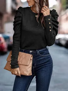 Detailed shot of elegant black slim fit top with stylish puff sleeves and gold cuff buttons