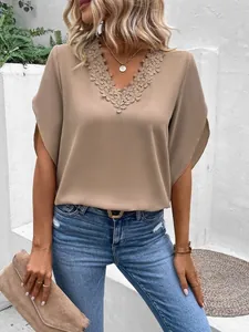Close-up view of elegant V-neck blouse with intricate lace trim and bell sleeves.