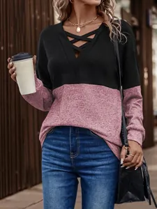 Detailed close-up of colorblock long sleeve top with stylish criss-cross V-neck.