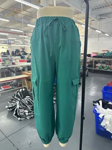Vista detallada de los pantalones cargo informales de mujer en color verde liso con bolsillos.