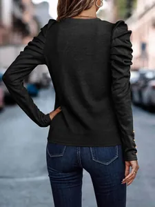 Back view of black slim fit top with elegant puff sleeves and cuff button details