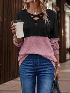 Macro view of the V-neck criss-cross strap detail on a two-tone color-block top.