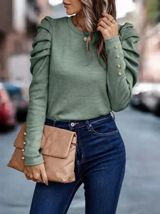 Detail view of a green puff sleeve knit top featuring elegant gold buttons on the cuffs.