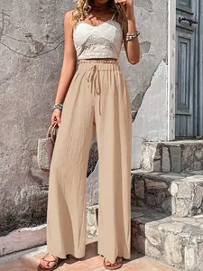 Detail view of casual beige wide-leg pants with elastic drawstring waist and bubble grid fabric.