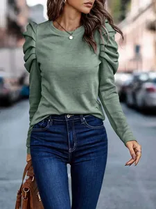 Close-up of women's sage green long-sleeved top with elegant puffed shoulder detail