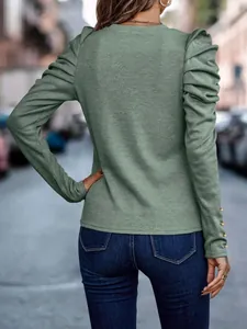 Detail view of sage green top with ruched puff sleeves and gold cuff button accents