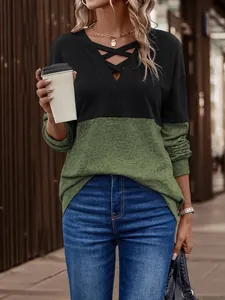 Detail view of casual women's color-block V-neck top featuring unique criss-cross strap design