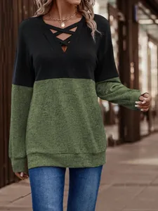 Close-up detail of women's color-block V-neck sweatshirt with crisscross strap design
