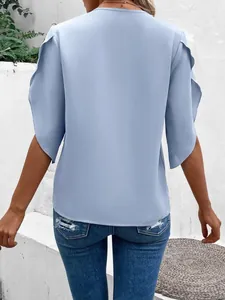 Back view of light blue petal sleeve blouse with casual summer distressed denim jeans.