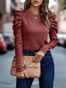 Detailed view of burgundy slim-fit top with elegant puff sleeves and decorative buttons