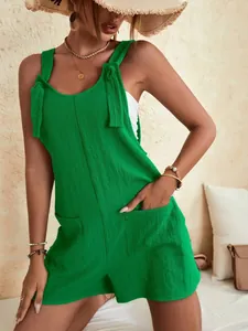 Combi-short d'été vert décontracté avec bretelles à nouer et poches avant élégantes.