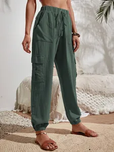 Vista detallada de pantalones cargo informales verde oscuro para mujer con bolsillos.