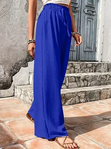 Detailed view of blue bubble-grid textured wide-leg casual pants worn by a model