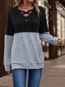 Detail view of women's V-neck long sleeve top with cross straps and grey color block
