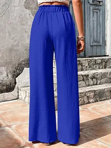 Rear view of vibrant blue wide-leg trousers in textured bubble crepe fabric detail